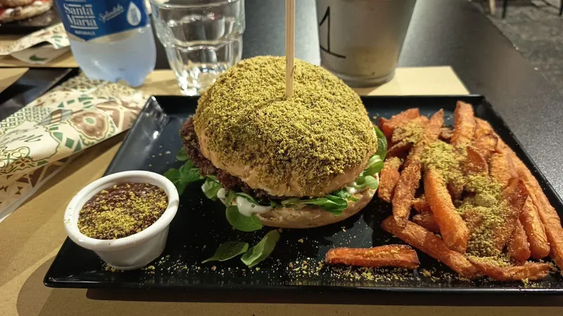 Hamburguesa al pistacho con patatas dulces americanas en bandeja negra